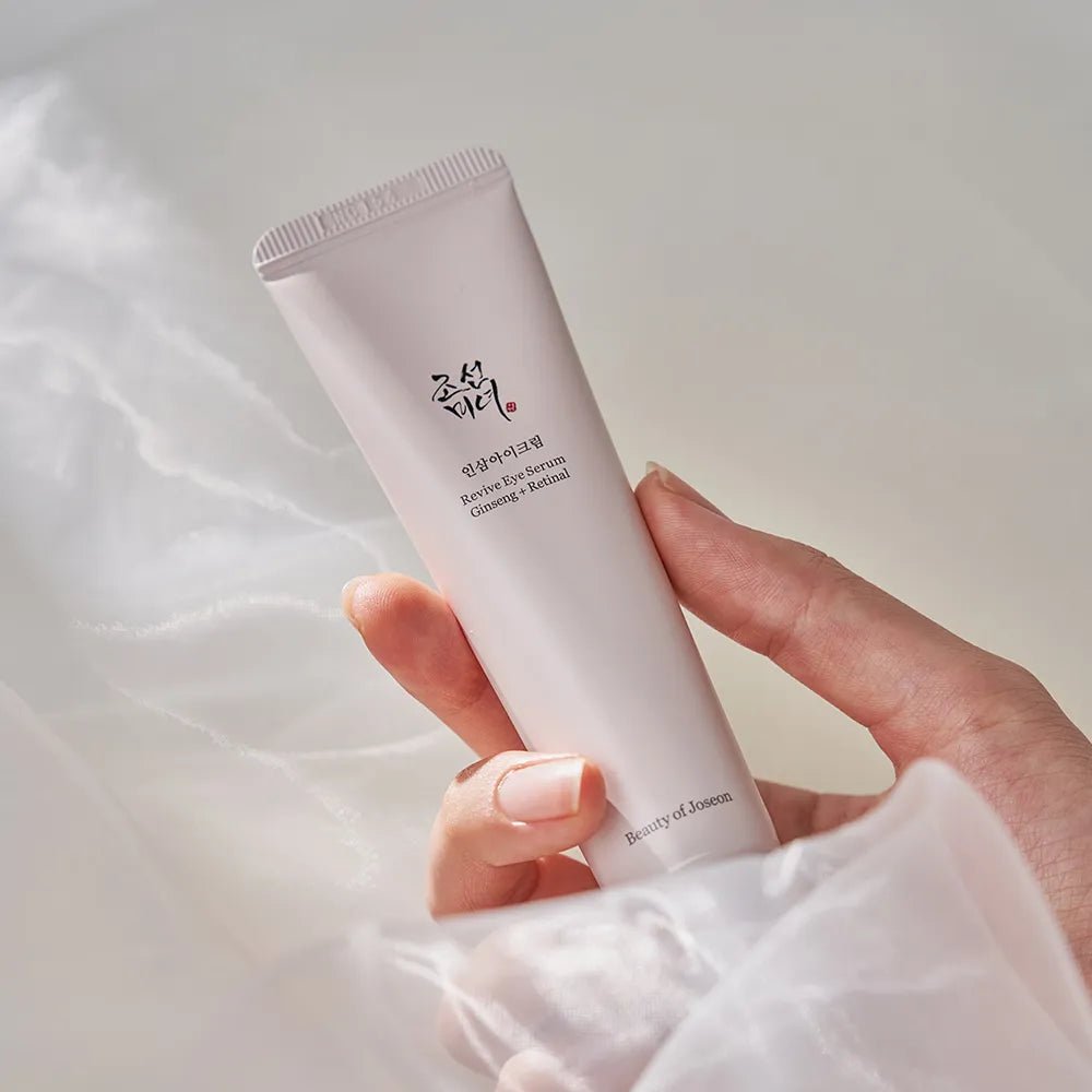 Hand holding Beauty of Joseon Revive Eye Serum Ginseng + Retinal 30ml on white fabric